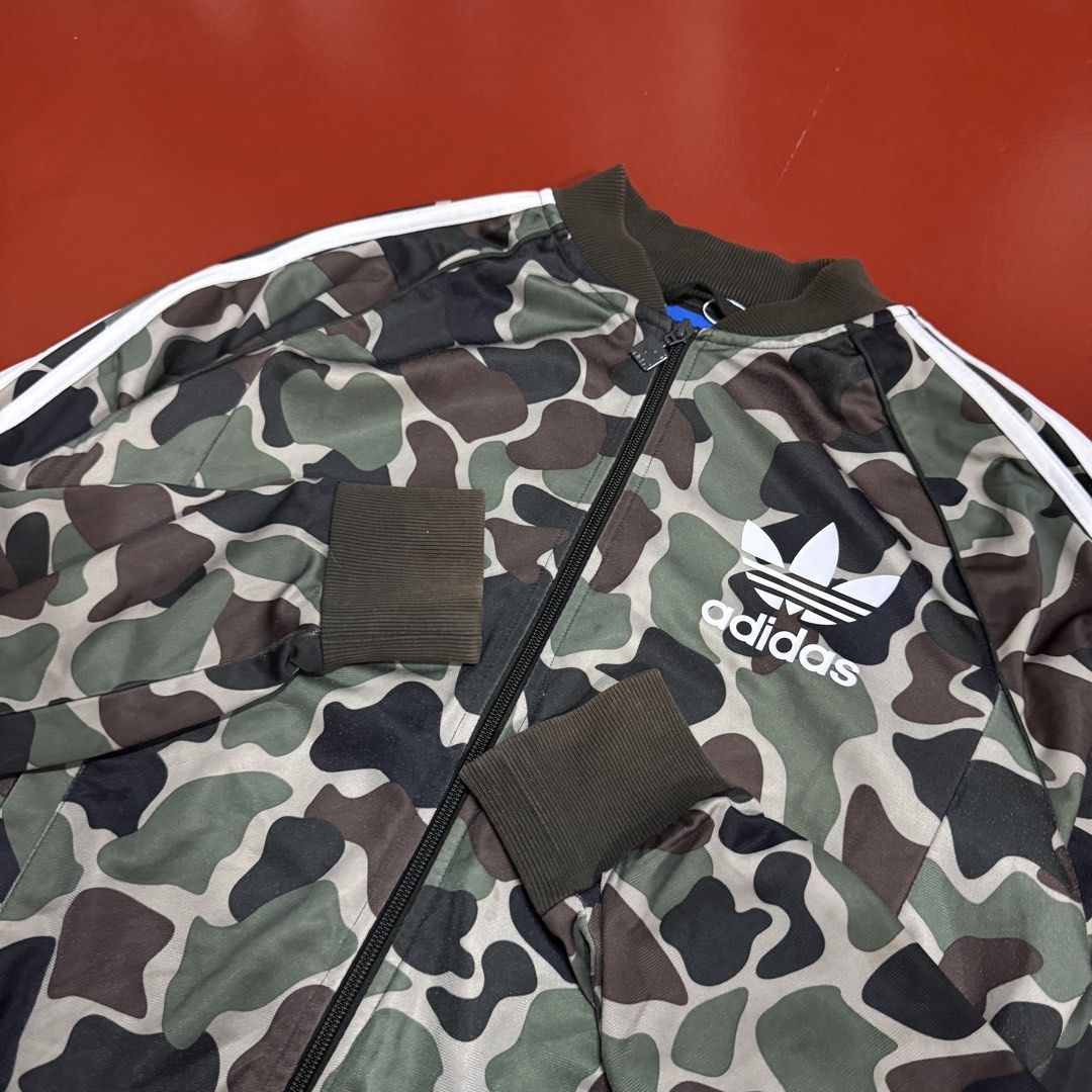 ADIDAS CAMOUFLAGE TRACK JACKET (Category: Coats, Jackets and Outerwear) located in Pasig City. Submitted by buzzthrifty (Listing ID 1464891927, Image 3). Description: SIZE S-M MEN M-L WOMEN 20x26 LINTS SA LOWER PART LAST PIC .