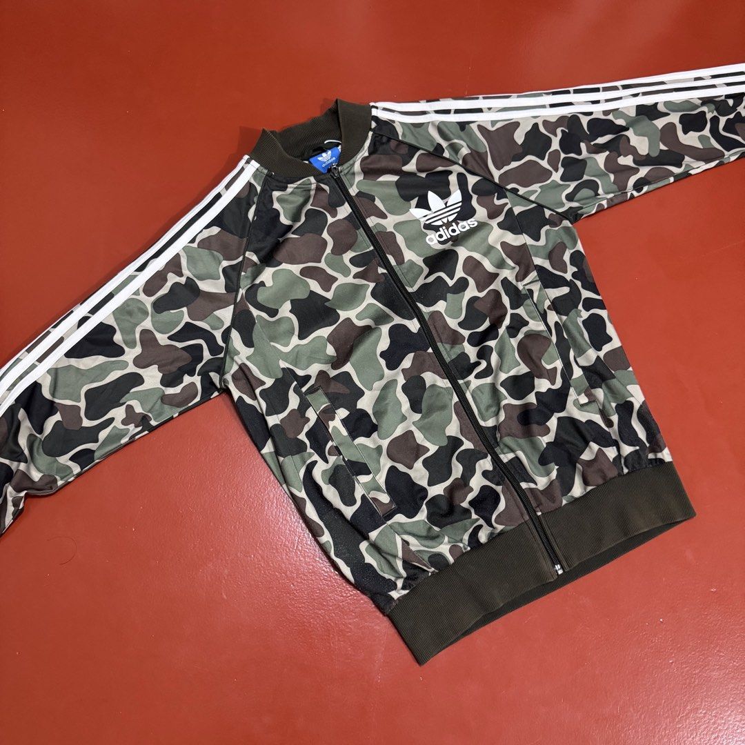 ADIDAS CAMOUFLAGE TRACK JACKET (Category: Coats, Jackets and Outerwear) located in Pasig City. Submitted by buzzthrifty (Listing ID 1464891927, Image 1). Description: SIZE S-M MEN M-L WOMEN 20x26 LINTS SA LOWER PART LAST PIC .