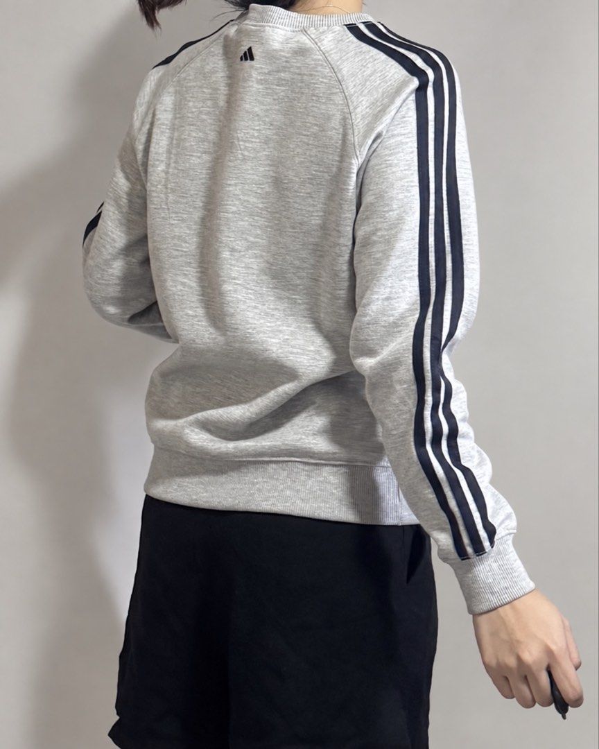 Adidas Grey Three-Stripe Sweatshirt (Category: Coats, Jackets and Outerwear) located in Marikina City. Submitted by xyrezsani (Listing ID 1464901070, Image 2). Description: - Brand: Adidas - Color: Grey with black three-stripe detailing - Design: Classic crewneck, ribbed cuffs and hem - Logo: Small printed Adidas logo on chest and emblem near collar - Fit: Comfortable for everyday casual wear - Condition: Brand new / Excellent (ready to ship).