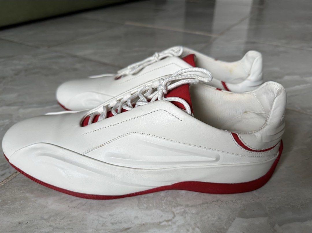 Adidas Porsche Design White Red Sneakers (Category: Casual Shoes) located in Binan City. Submitted by itiantimbol27 (Listing ID 1464894772, Image 1). Description: - Authentic Porsche Design sneakers in white leather with vibrant red accents and soles - Chunky rounded silhouette with a stylish driving shoe aesthetic - Features embossed Porsche Design branding on the heel and printed insoles - Textured outsole for reliable grip - Excellent pre-love
