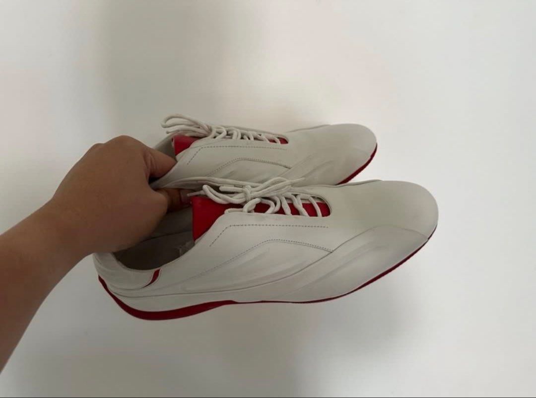 Adidas Porsche Design White Red Sneakers (Category: Casual Shoes) located in Binan City. Submitted by itiantimbol27 (Listing ID 1464894772, Image 3). Description: - Authentic Porsche Design sneakers in white leather with vibrant red accents and soles - Chunky rounded silhouette with a stylish driving shoe aesthetic - Features embossed Porsche Design branding on the heel and printed insoles - Textured outsole for reliable grip - Excellent pre-love