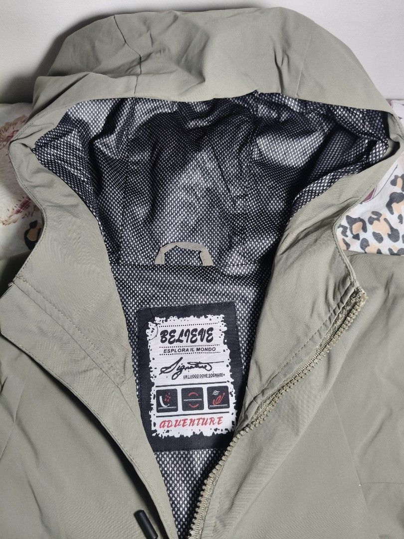 Adventure Wind Breaker (Category: Coats, Jackets and Outerwear) located in Lapu Lapu. Submitted by hooman422 (Listing ID 1464917989, Image 2). Description: • Style: Technical hooded windbreaker or light rain jacket. • Color: Matte olive drab / khaki green. • Closure: Full-length front zipper with an extended chin guard. • Hood: Attached hood with adjustable elastic drawcords and a dark mesh lining. • Pockets: Four front zippered pockets, includin