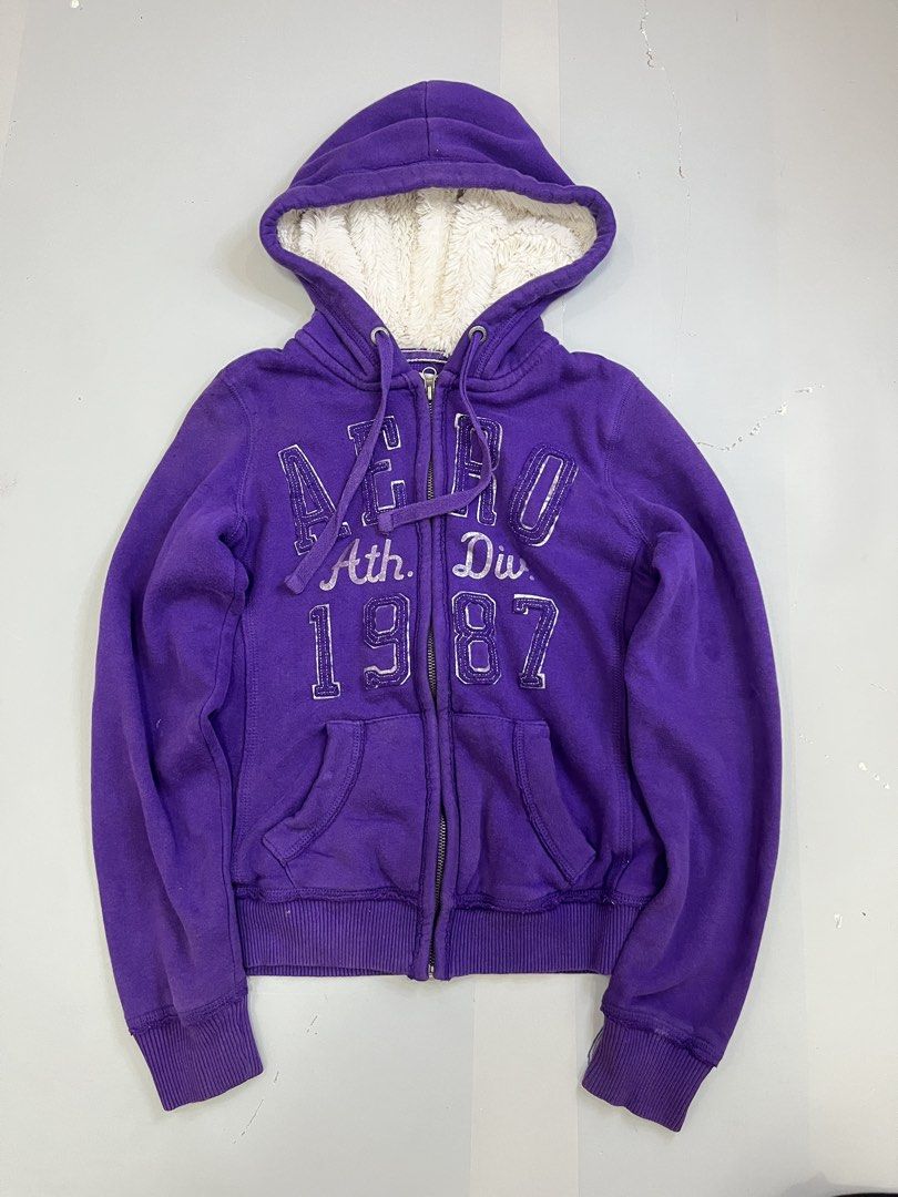Aeropostale Fur Jacket (Category: Coats, Jackets and Outerwear) located in Mabalacat. Submitted by aas_thriftfings (Listing ID 1464783432, Image 1). Description: - Brand: Aeropostale - Color: Purple with silver distressed chest lettering ('Aero Ath. Div. 1987') - Lining: Cozy white fuzzy sherpa inside the hood - Features: Full zip-up, front pockets, and matching drawstring cords - Details: Ribbed cuffs and hem for extra comfort and fit - Conditio
