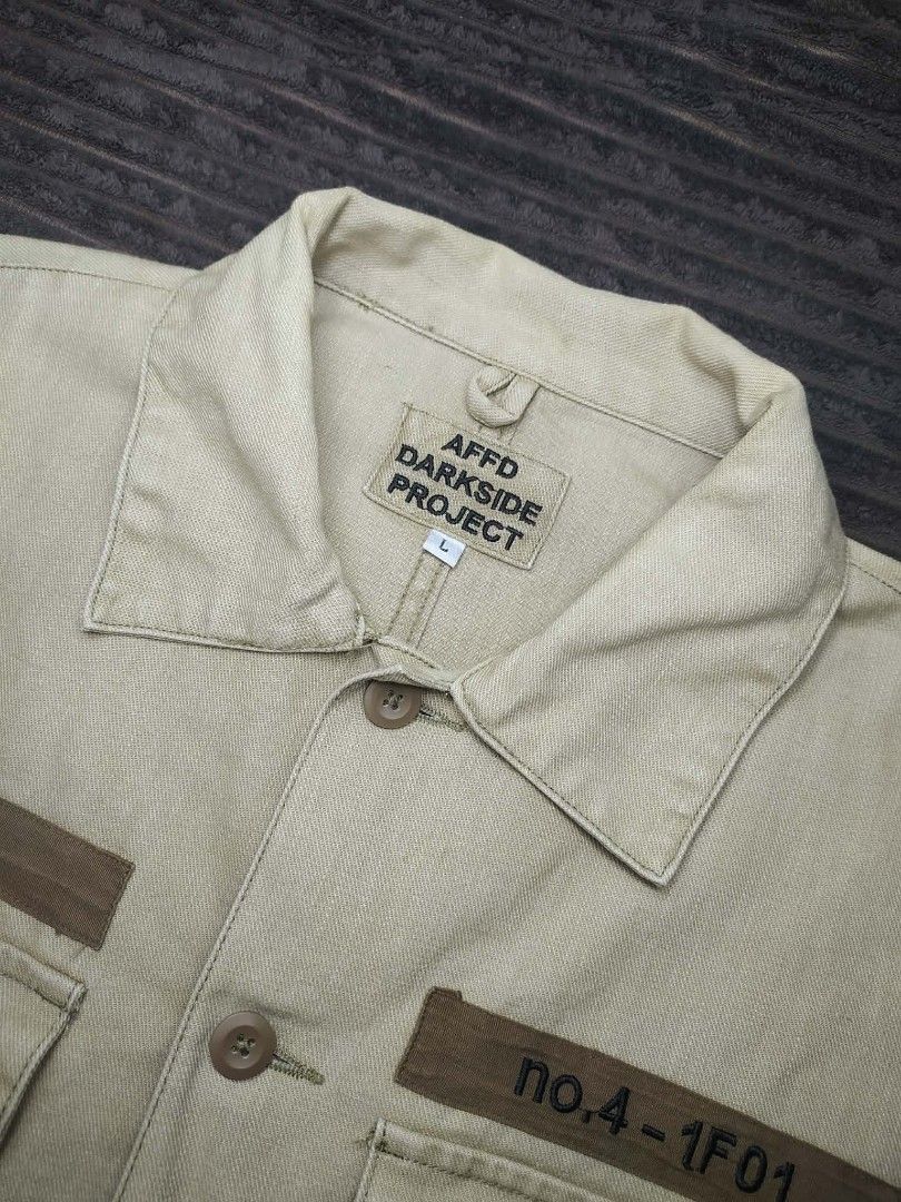 AFFD Darkside Project Utility Shirt Khaki Size L (Category: Tshirts & Polo Shirts ) located in Manila. Submitted by norathrifted (Listing ID 1464792318, Image 3). Description: - Brand/Model: AFFD Darkside Project - Size: Large - Color: Khaki - Material: Structured cotton - Closure: Button-front with matching brown buttons - Pockets: Two chest pockets with button flaps - Details: Printed lettering above both pockets, classic collar, and long sleev