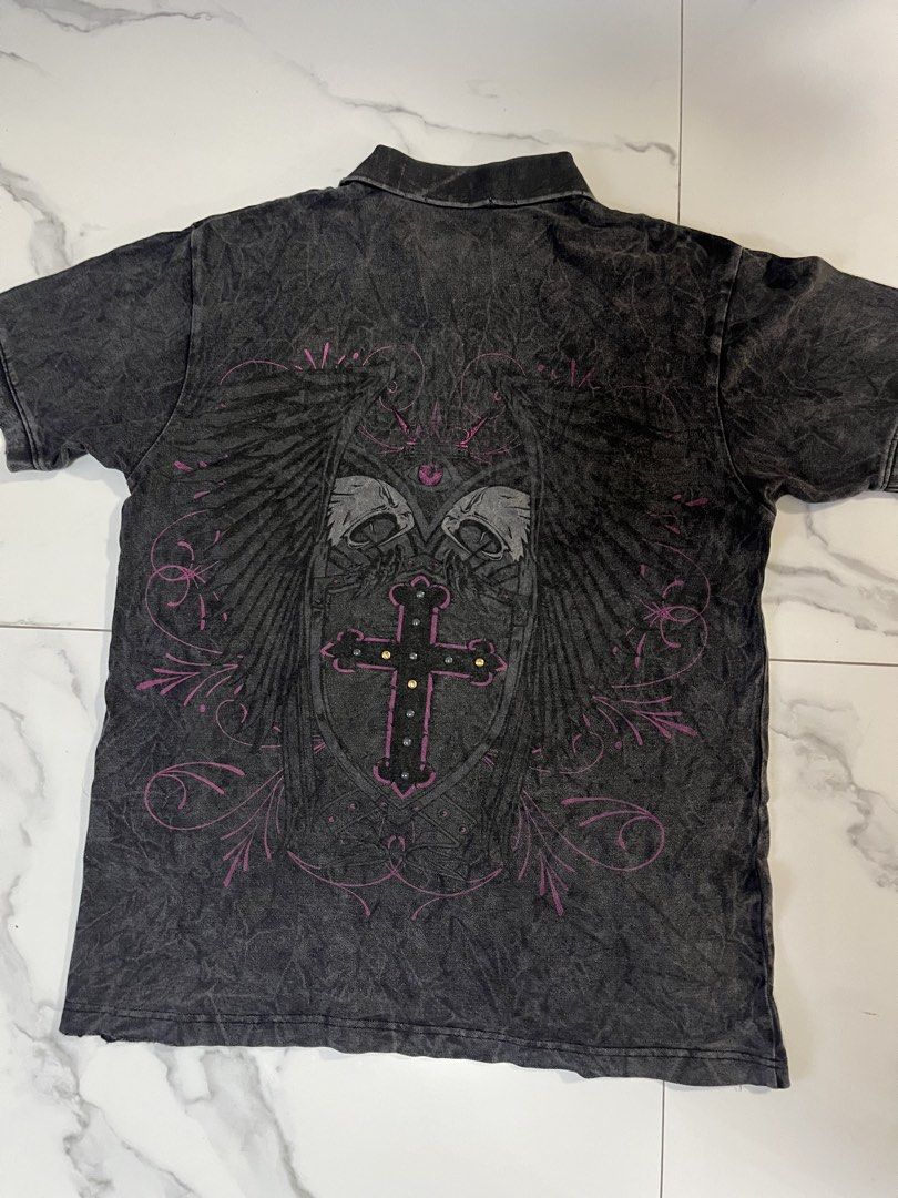 Affliction alt polo wings (Category: Tshirts & Polo Shirts ) located in Caloocan City. Submitted by crucifiedtearz (Listing ID 1464782243, Image 3). Description: - Brand: Sail Soho - Color: Black acid wash - Size: Medium - Style: Short sleeve polo with 3-button placket - Front Detail: Embellished studded cross design on the left chest - Back Detail: Large, detailed graphic featuring wings, skulls, a shield, and a studded cross with pink scrollwor