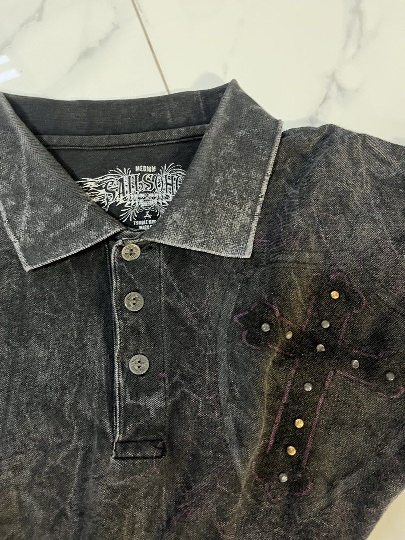 Affliction alt polo wings (Category: Tshirts & Polo Shirts ) located in Caloocan City. Submitted by crucifiedtearz (Listing ID 1464782243, Image 2). Description: - Brand: Sail Soho - Color: Black acid wash - Size: Medium - Style: Short sleeve polo with 3-button placket - Front Detail: Embellished studded cross design on the left chest - Back Detail: Large, detailed graphic featuring wings, skulls, a shield, and a studded cross with pink scrollwor