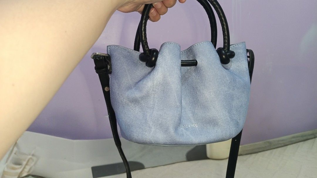 Age Free Light Blue Denim Bucket Bag with Black Straps (Category: Tote Bags) located in Manila. Submitted by ysabelgale09807 (Listing ID 1464802489, Image 2). Description: - Brand: Bags Free - Material: Light blue denim with black top handles and silver hardware - Straps: Includes black top handles and a long adjustable shoulder strap - Design: Structured bottom, gathered top edge detail - Interior: Patterned fabric lining with a convenient cente