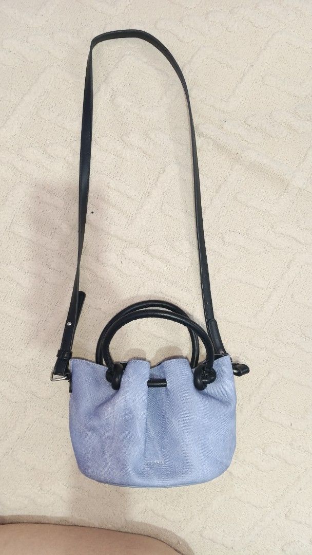 Age Free Light Blue Denim Bucket Bag with Black Straps (Category: Tote Bags) located in Manila. Submitted by ysabelgale09807 (Listing ID 1464802489, Image 1). Description: - Brand: Bags Free - Material: Light blue denim with black top handles and silver hardware - Straps: Includes black top handles and a long adjustable shoulder strap - Design: Structured bottom, gathered top edge detail - Interior: Patterned fabric lining with a convenient cente