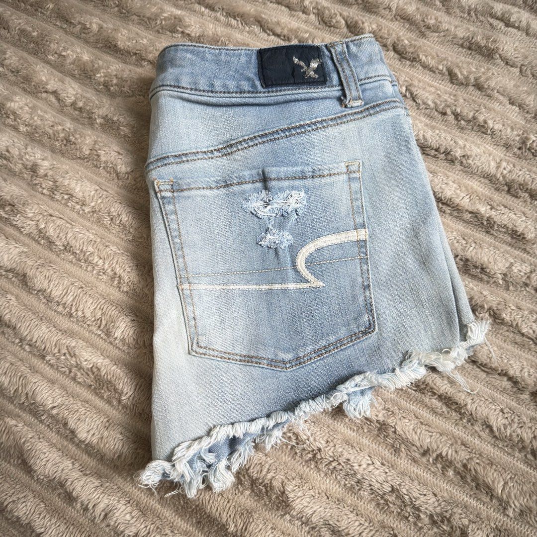 American Eagle Distressed Denim Shorts (Category: Shorts) located in Quezon City. Submitted by lovedbelongings (Listing ID 1464799354, Image 1). Description: - Brand: American Eagle - Style: Mid-rise denim shorts in light blue wash - Details: Heavy distressing, frayed raw hems, and visible pocket lining - Closure: Button and zipper fly - Pockets: Functional front and back pockets - Condition: Super casual, ready to wear.