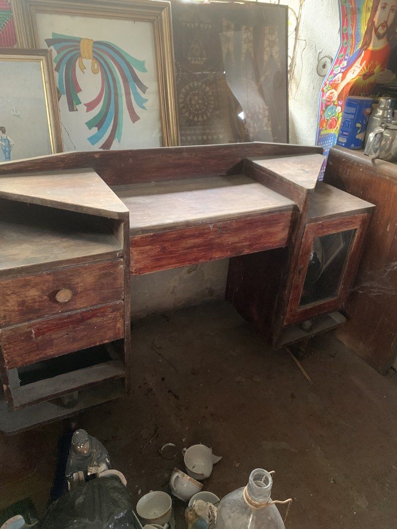 Antique narra dresser (Category: Tables & Sets) located in Quezon City. Submitted by sojisup (Listing ID 1464879923, Image 3). Description: - Vintage wooden vanity table with a charming reddish-brown finish - Features a large central desktop, raised backboard, and corner ledges - Multi-level shelving and multiple drawers on the left - Glass-paneled cabinet door on the right - Sturdy and solid build, perfect for a restoration project - Needs a goo