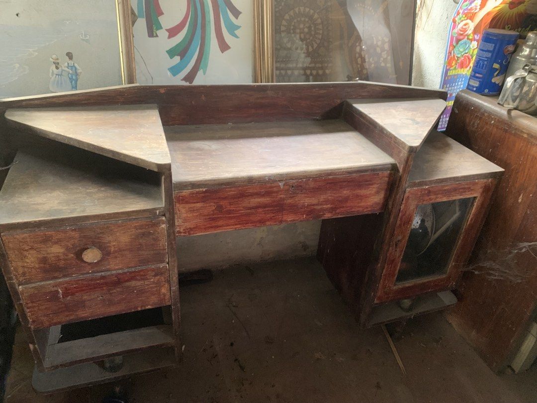 Antique narra dresser (Category: Tables & Sets) located in Quezon City. Submitted by sojisup (Listing ID 1464879923, Image 1). Description: - Vintage wooden vanity table with a charming reddish-brown finish - Features a large central desktop, raised backboard, and corner ledges - Multi-level shelving and multiple drawers on the left - Glass-paneled cabinet door on the right - Sturdy and solid build, perfect for a restoration project - Needs a goo