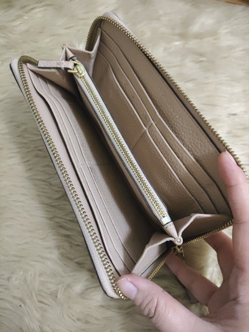 Authentic Tory Burch McGraw zip around long wallet (Category: Wallets & Card holders) located in Rizal. Submitted by hsiri1128 (Listing ID 1464884007, Image 2). Description: 💯✔️Legit CONDITION : 8/10 ISSUE / FLAWS : None. normal signs of wear only MATERIAL : Genuine pebbled leather w/ gold hardwares DETAILS : Beige actual color. good condition ykk zip. ok pa rubberseals. no crackings.