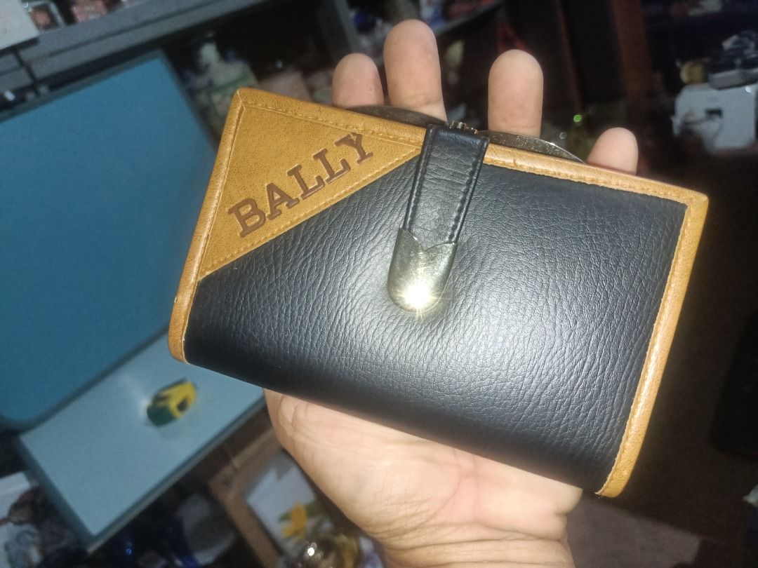 Bally leather wallet black and brown (Category: Wallets & Card Holders) located in Munoz. Submitted by larryc1212 (Listing ID 1464899398, Image 1). Description: - Authentic Bally bi-fold wallet made in Italy - Stylish black and tan leather mix with elegant gold foil logo - Secure snap button closure and vintage-style kiss-lock coin compartment - Multiple card slots and convenient ID window inside - Condition: Shows some edge wear and natural agin