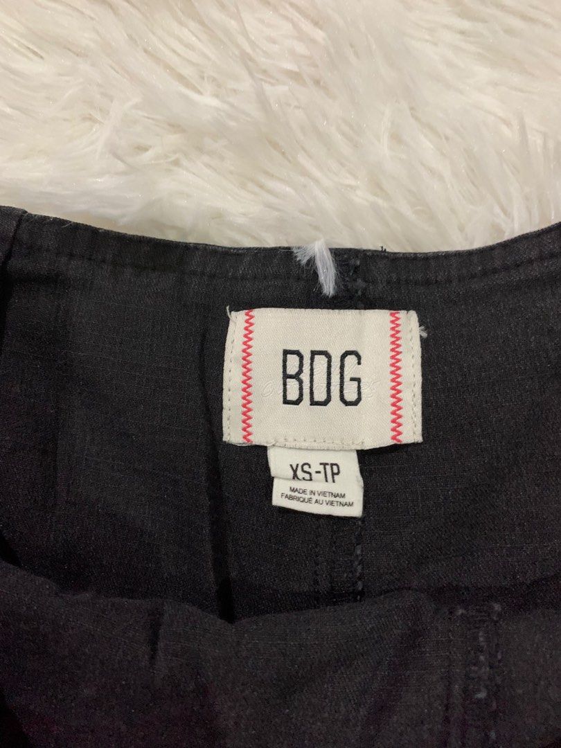 BDG Black Denim Pleated Skort Size XS (Category: Skirts) located in Iba. Submitted by thriftcoyan (Listing ID 1464886576, Image 3). Description: - Brand: BDG - Size: XS - Color: Washed black - Style: Y2K pleated front with side buckle detail - Features: Built-in shorts underneath, side zipper closure - Condition: Great trendy piece, easy to pair with baby tees or boots - Note: Measurements available upon request.