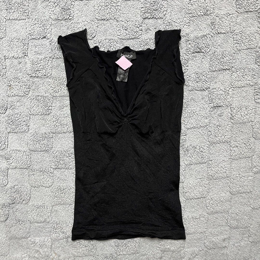 bebe Black Ruffle Trim V-Neck Sleeveless Top (Category: Sleeveless) located in Tarlac. Submitted by thriftspot2024 (Listing ID 1464809211, Image 1). Description: - Brand: bebe - Size: P/S - Color: Black - Style: Y2K aesthetic, sleeveless, ruffled V-neck, center ruching, ribbed lower body - Material: 92% nylon, 8% spandex - Origin: Made in U.S.A..