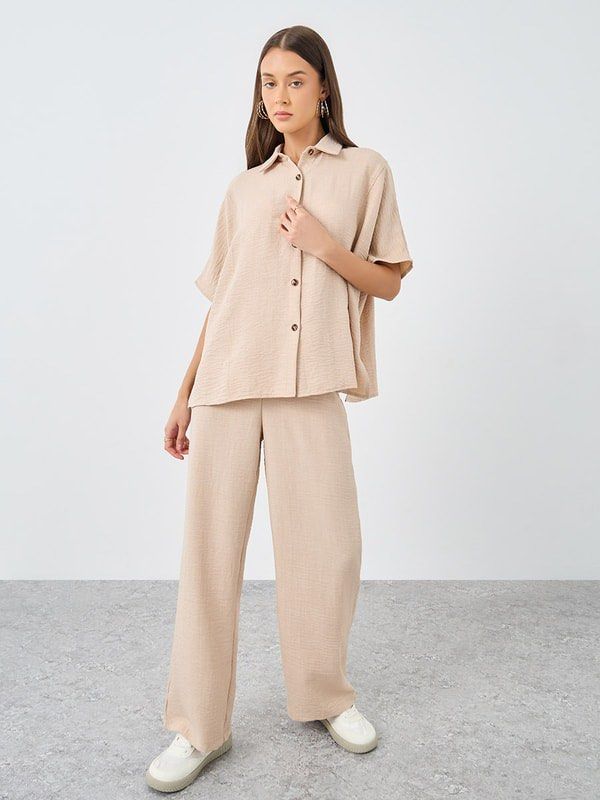 Beige Coordinates (Category: Sets or Coordinates) located in Quezon City. Submitted by closetcleanupfairy (Listing ID 1464831174, Image 1). Description: - Set includes: Short-sleeve button-down top with front pocket and collar + matching wide-leg trousers - Material: Lightweight textured crinkle fabric - Fit: Relaxed and comfortable.