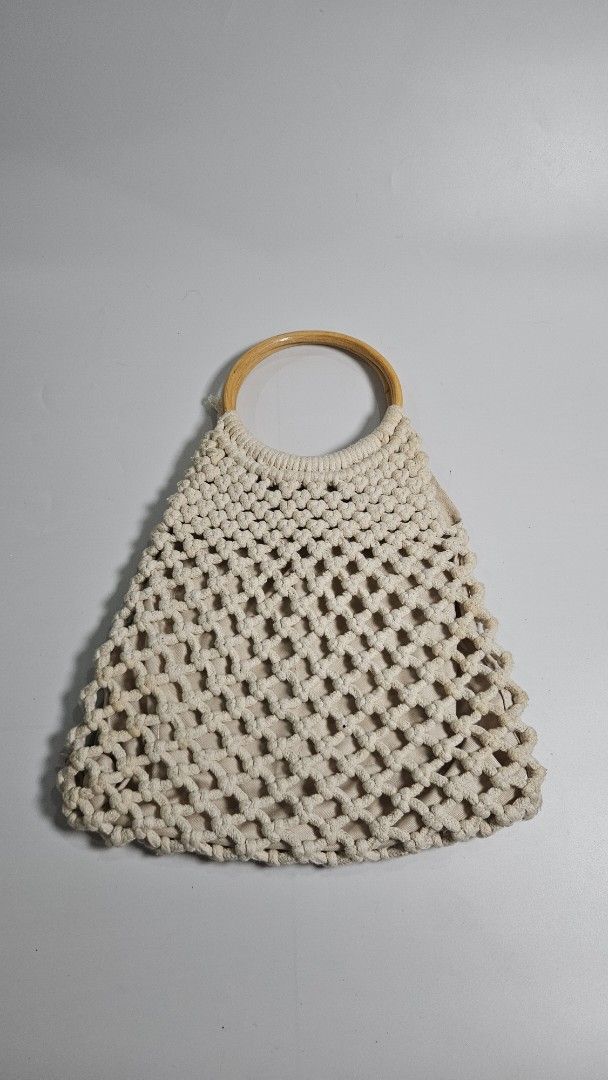 Beige Macrame Crochet Handbag with Bamboo Ring Handles (Category: Shoulder Bags) located in Alfonso. Submitted by jbcamet (Listing ID 1464908787, Image 1). Description: - Trendy beige crochet macrame handbag in a stylish triangular shape - Sturdy wooden ring handles on each side for an effortless boho look - Fully lined interior with a secure magnetic snap closure - Practical storage includes 1 inner zipper pocket and 1 slip pocket - Neutral crea