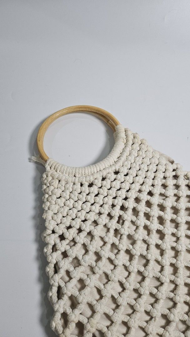 Beige Macrame Crochet Handbag with Bamboo Ring Handles (Category: Shoulder Bags) located in Alfonso. Submitted by jbcamet (Listing ID 1464908787, Image 2). Description: - Trendy beige crochet macrame handbag in a stylish triangular shape - Sturdy wooden ring handles on each side for an effortless boho look - Fully lined interior with a secure magnetic snap closure - Practical storage includes 1 inner zipper pocket and 1 slip pocket - Neutral crea