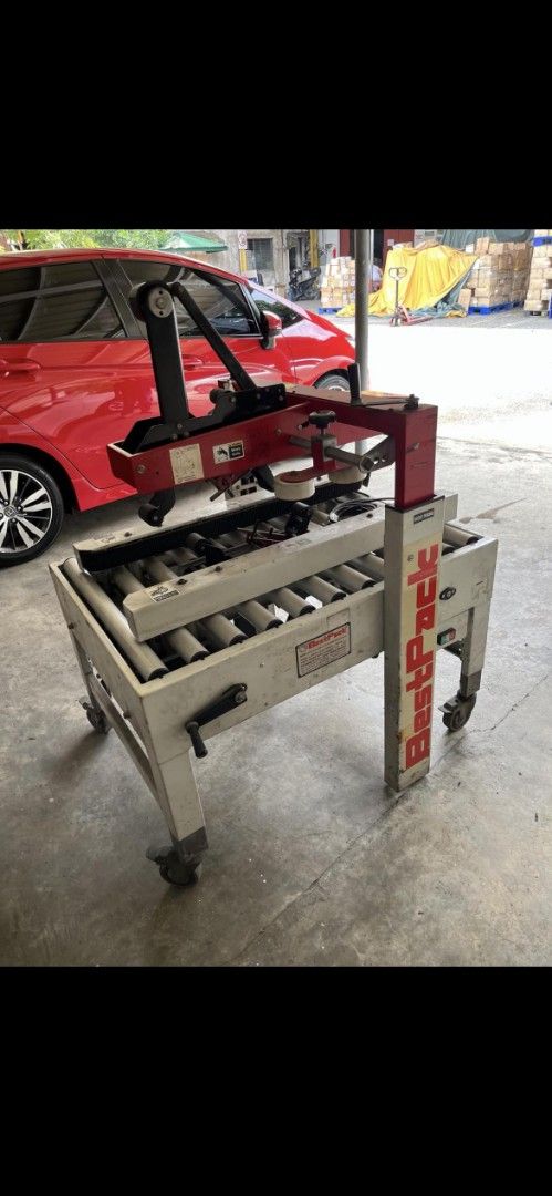 BestPack Carton Sealer Packaging Machine (Category: Industrial Equipment) located in Quezon City. Submitted by nhatedaniel2293164 (Listing ID 1464932821, Image 1). Description: - Heavy-duty BestPack carton sealer ideal for warehouse and shipping operations - Built with a durable metal frame, roller conveyor deck, and red top assembly with tape head - Equipped with an adjustable height handle for comfortable use - Mounted on swivel wheels with bra