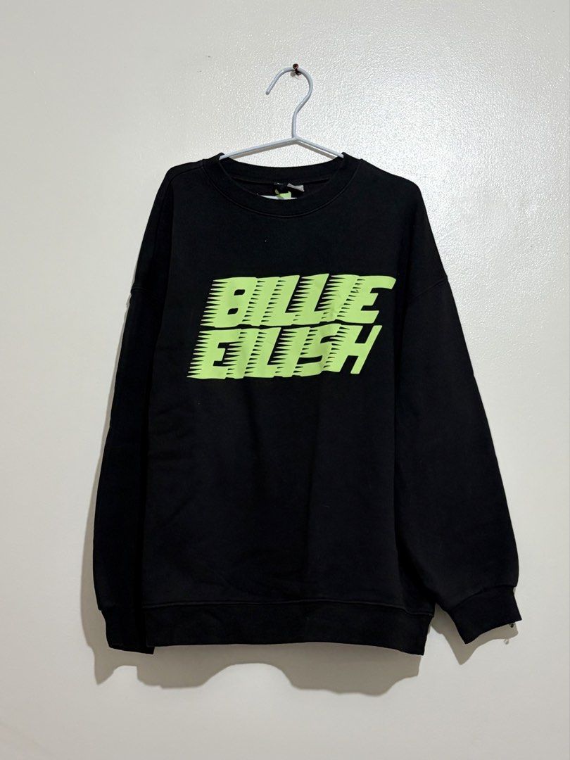 Divided by H&M Billie Eilish Black Sweatshirt (Category: Longsleeves) located in Cainta. Submitted by knarv__ (Listing ID 1464883434, Image 1). Description: H&M Divided x Billie Eilish black sweatshirt in Size S. Features a neon green graffiti logo, comfy fleece lining, and a classic crewneck..