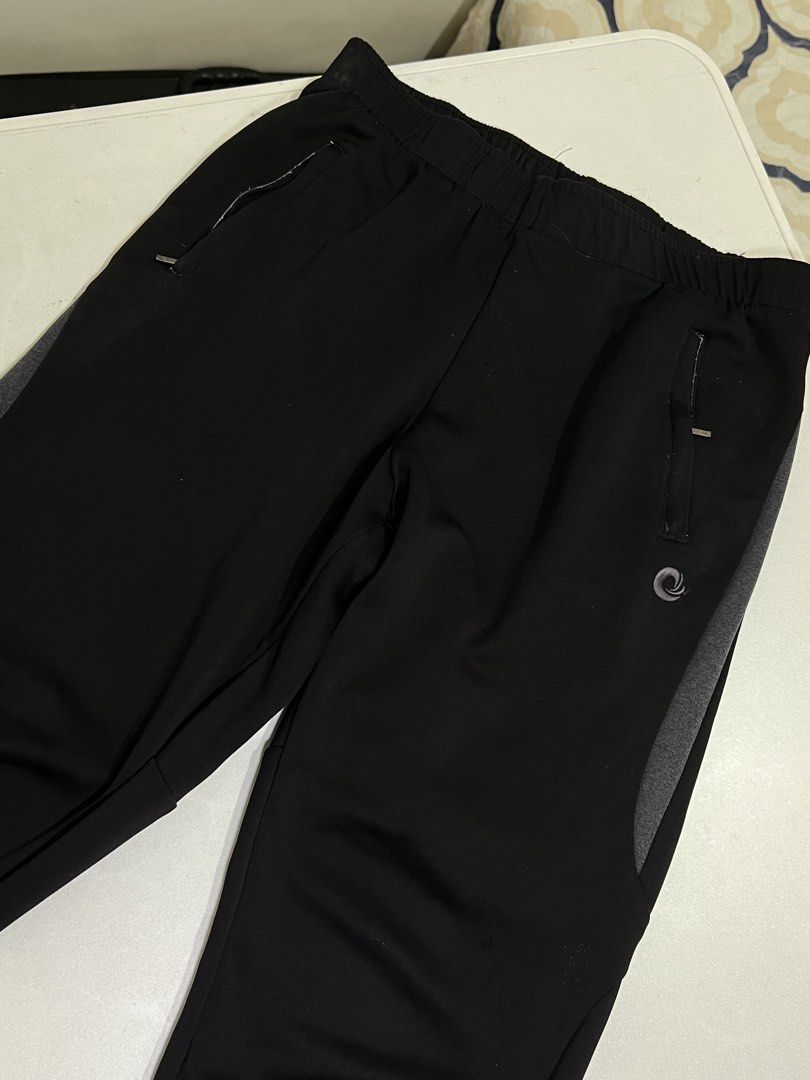 Black Athletic Track Pants with Zipper Pockets (Category: Joggers) located in Manila. Submitted by sennisen (Listing ID 1464922584, Image 2). Description: - Color: Black with stylish grey side panels - Fit: Comfortable elastic waistband for all-day wear - Storage: Two front zippered pockets to keep your essentials safe - Material: Lightweight fabric designed for easy movement - Details: Features a small swirl logo near the left pocket with clean 