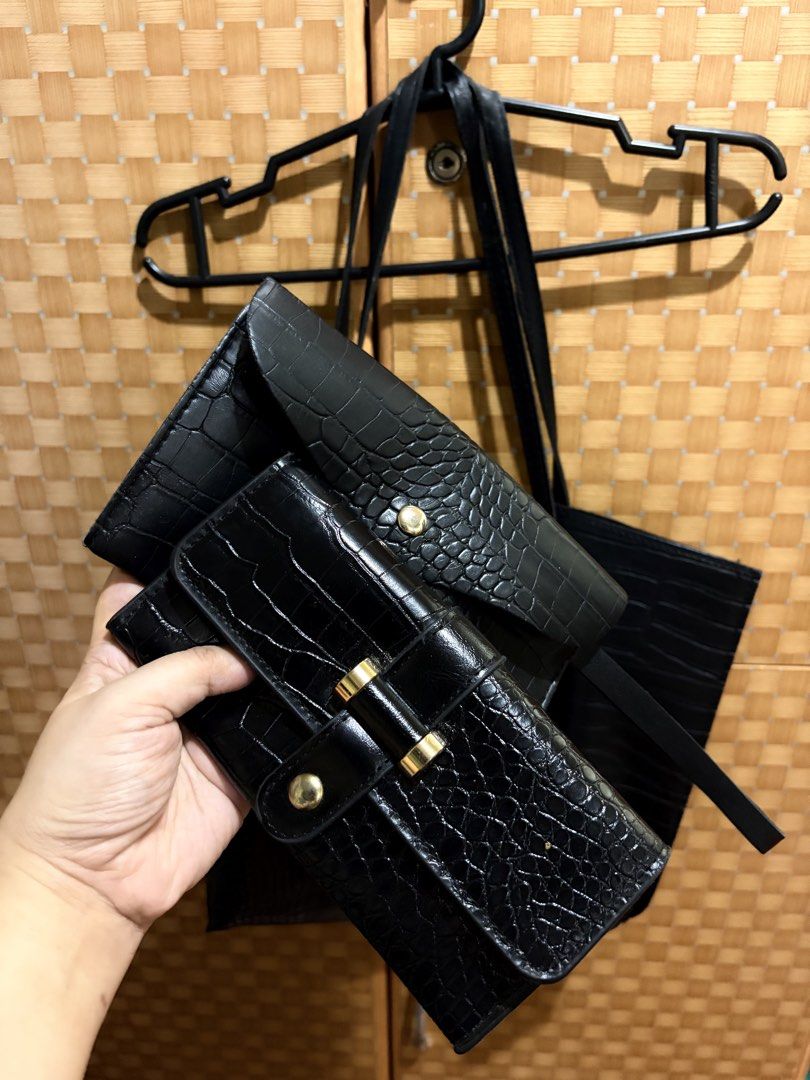 Black crocodile embossed tote bag and wallet set (Category: Tote Bags) located in Pangil. Submitted by chel_anne (Listing ID 1464828340, Image 3). Description: - Complete set: 1 large tote bag and 2 matching wallets - Material: Stylish faux crocodile leather texture - Tote features: Long shoulder straps, secure snap button closure, and spacious interior - Wallet features: Elegant gold-tone hardware with secure closures - Condition: Clean inside a