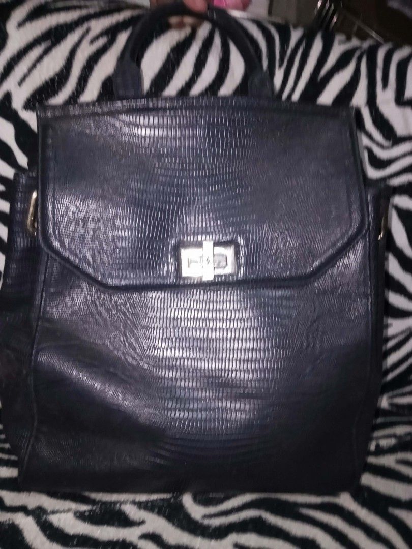 Black faux leather textured backpack with top handle (Category: Backpacks) located in Valenzuela. Submitted by rowenasalvador777 (Listing ID 1464967911, Image 1). Description: - Material: Premium textured faux leather in versatile black - Closure: Secure flap front with a sleek silver metal turn-lock clasp - Design: Structured shape that holds its form with a convenient small top handle - Storage: Deep main compartment for all your daily essentia