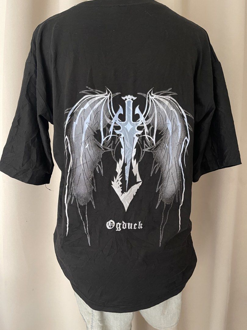 Black Graphic Tee (Category: Shirts) located in Cainta. Submitted by zlove111 (Listing ID 1464807714, Image 1). Description: - Material: Soft, comfortable cotton - Design: Small wing and sword graphic on left chest, massive gothic wing sword artwork on the back - Style: Great for daily wear, pairs easily with jeans or cargo pants large 20".