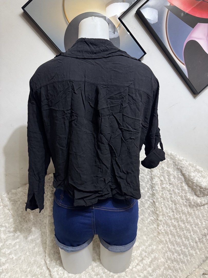 Black long sleeve button down tied front shirt blouse (Category: Longsleeves) located in Marikina City. Submitted by lorradel (Listing ID 1464897032, Image 3). Description: - fits M-L - Color: Black - Style: Button-down blouse with front tie detail - Sleeves: Long sleeves with rolled-up tab and button fasteners - Neckline: Classic collar - Fit: Relaxed fit in lightweight fabric - Versatility: Easy to pair with denim shorts or high-waisted jeans f
