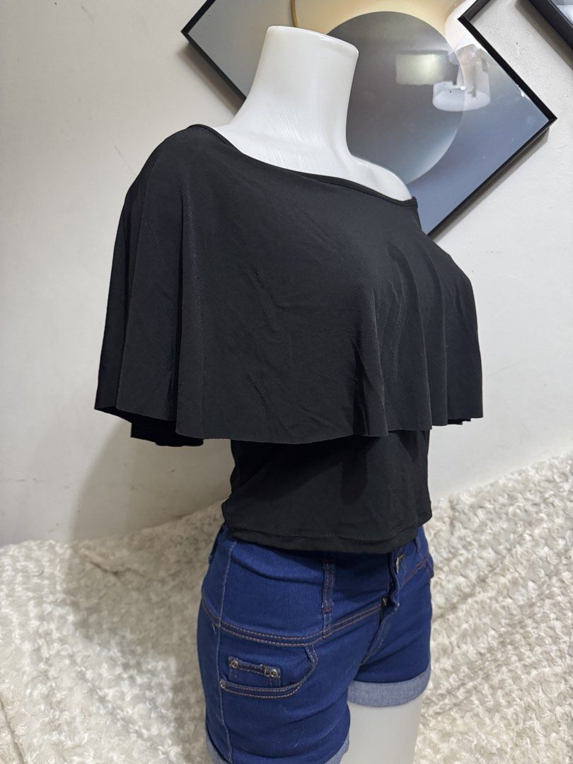 Black One-Shoulder Ruffle Overlay Crop Top (Category: Sleeveless) located in Marikina City. Submitted by lorradel (Listing ID 1464905474, Image 3). Description: - Color: Black - Style: Off-shoulder short sleeve top with a draped chest ruffle - Fit: Snug, body-hugging fit with stretchy fabric for comfort - Design: Easy pull-on style - Pairing: Looks great with high-waisted denim shorts - MAY HAVE some washable stains (hindi maiiwasan) needs washin