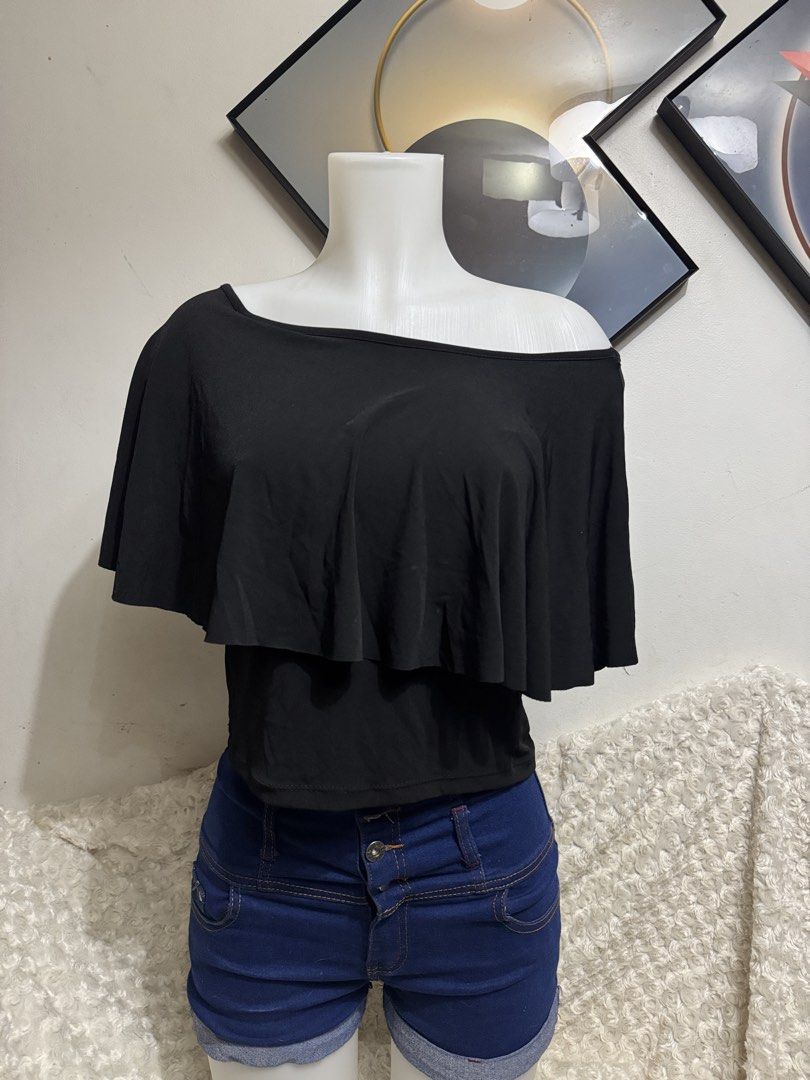 Black One-Shoulder Ruffle Overlay Crop Top (Category: Sleeveless) located in Marikina City. Submitted by lorradel (Listing ID 1464905474, Image 1). Description: - Color: Black - Style: Off-shoulder short sleeve top with a draped chest ruffle - Fit: Snug, body-hugging fit with stretchy fabric for comfort - Design: Easy pull-on style - Pairing: Looks great with high-waisted denim shorts - MAY HAVE some washable stains (hindi maiiwasan) needs washin