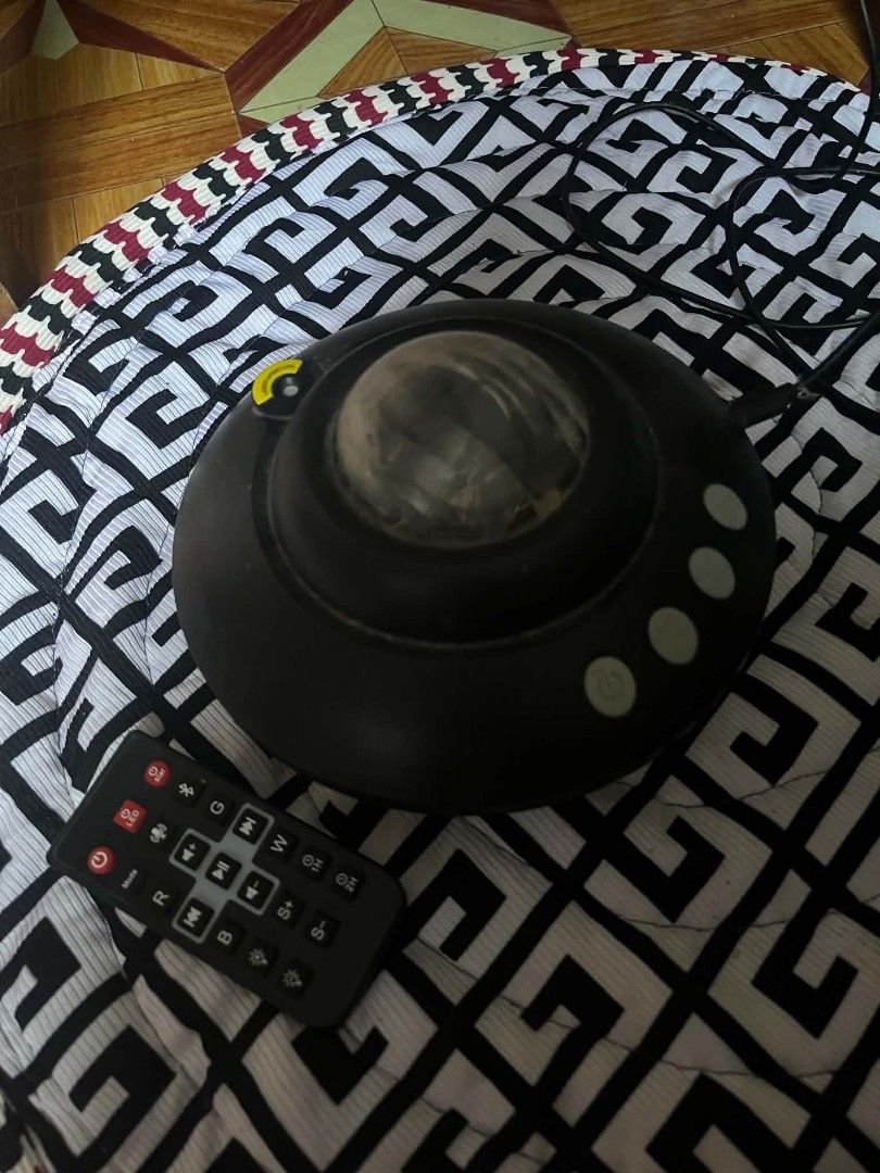 Black Star Projector Night Light with Remote Control (Category: Projectors) located in Los Banos. Submitted by riozoe24 (Listing ID 1464814904, Image 1). Description: - Color/Design: Sleek black star projector with a dome top - Lighting: Cozy warm orange-yellow light and relaxing patterns - Control: Includes a remote control for easy adjustment of settings, brightness, and modes - Power: Comes with an attached power cable (plug and play) - Ideal 