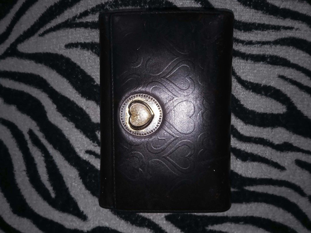 Black wallet with embossed heart pattern and gold clasp (Category: Wallets & Card holders) located in Valenzuela. Submitted by rowenasalvador777 (Listing ID 1464968644, Image 1). Description: - Color: Sleek black with dark hardware - Material: Premium black leather with embossed heart pattern - Closure: Secure round metallic button clasp with centered heart design - Size: Compact, fits easily into any handbag - Style: Simple and versatile everyda
