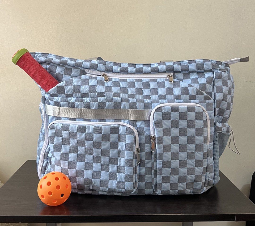 Blue and grey checkered pickleball tote bag (Category: Tote Bags) located in Manila. Submitted by kendsg (Listing ID 1464942528, Image 1). Description: - Stylish blue and grey checkered design - Spacious main compartment for all your gear - Dedicated paddle sleeve slot for secure storage - Multiple outside zippered pockets and compartments for organization - Mesh side pocket with drawstring toggle to hold balls safely - Equipped with convenient c
