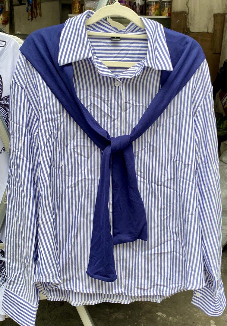 Blue and White Striped Long Sleeve Button-Down Shirt (Category: Longsleeves) located in Pateros City. Submitted by shin_0221 (Listing ID 1464797539, Image 1). Description: - Design: Classic blue and white vertical stripes - Fit: Relaxed fit, ideal for casual outfits or layering - Details: Standard collar, button-front closure, and long sleeves with matching striped cuffs - Bonus: Includes a chic dark blue fabric accessory draped and tied around t