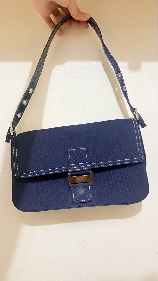 Blue denim Shoulder Bag With Contrast Stitching (Category: Shoulder Bags) located in Cagayan de Oro. Submitted by preloved_54 (Listing ID 1464894689, Image 1). Description: - Color & Material: Navy blue canvas with white contrast stitching - Hardware: Silver-tone with front flap buckle closure - Strap: Adjustable with stylish eyelet details - Interior: Clean lining with a zipper compartment and an extra pocket - Condition: Excellent, clean interi