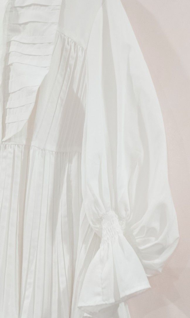 BNWT SNIDEL white Pintuck Frill Tunic Blouse (Category: Blouses) located in Cabanatuan. Submitted by miss.maia (Listing ID 1464847608, Image 3). Description: SNIDEL Pintuck Frill Tunic Blouse This romantic, vintage-inspired white top features a banded high-neck collar, a pleated bib-front panel with stitched accents, and dramatic, voluminous balloon sleeves that taper down into tiered ruffle cuffs. The lower half of the shirt is styled with verti