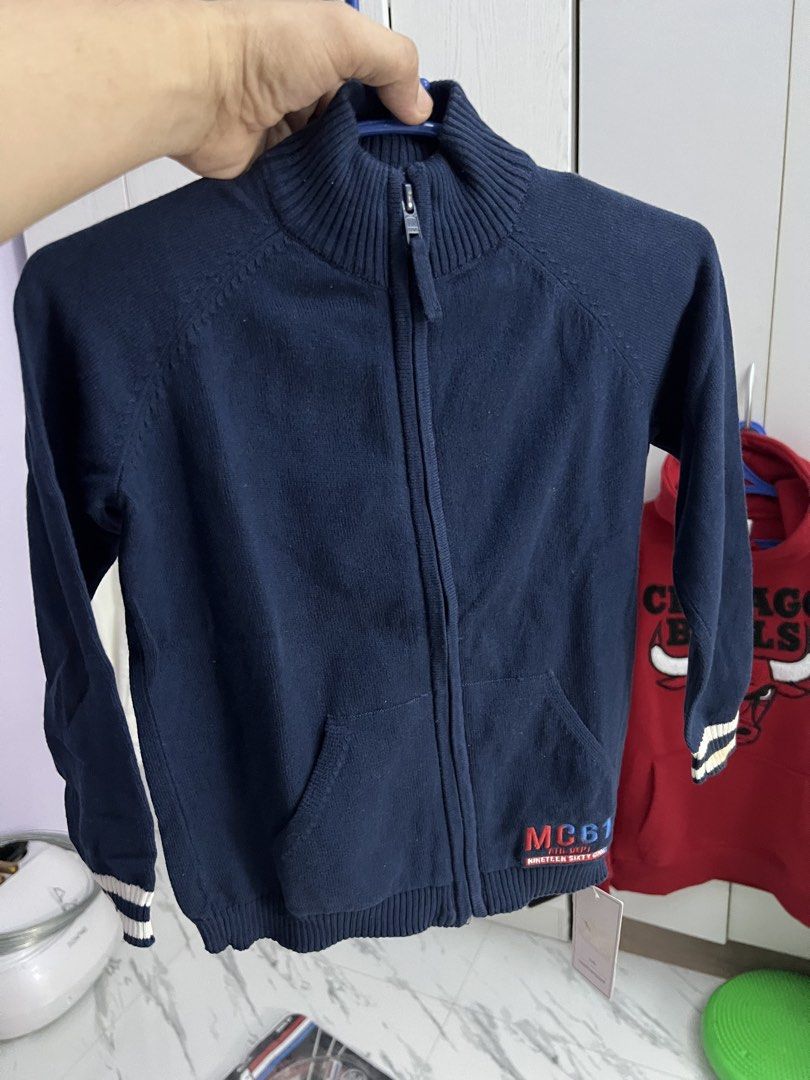 Boys Navy Blue Knit Zip-Up Jacket MC61 (Category: Babies & Kids Fashion) located in Gapan. Submitted by arieltinio (Listing ID 1464936852, Image 2). Description: - Brand: New with tags (BNWT) - Color: Navy blue with white & navy sleeve stripes - Style: Mock neck zip-up knit jacket with front kangaroo pocket - Details: Ribbed cuffs/hem, embroidered 'MC61 Ath. Dept.' patch - Condition: Brand new, never worn - Perfect for: Casual everyday wear or co