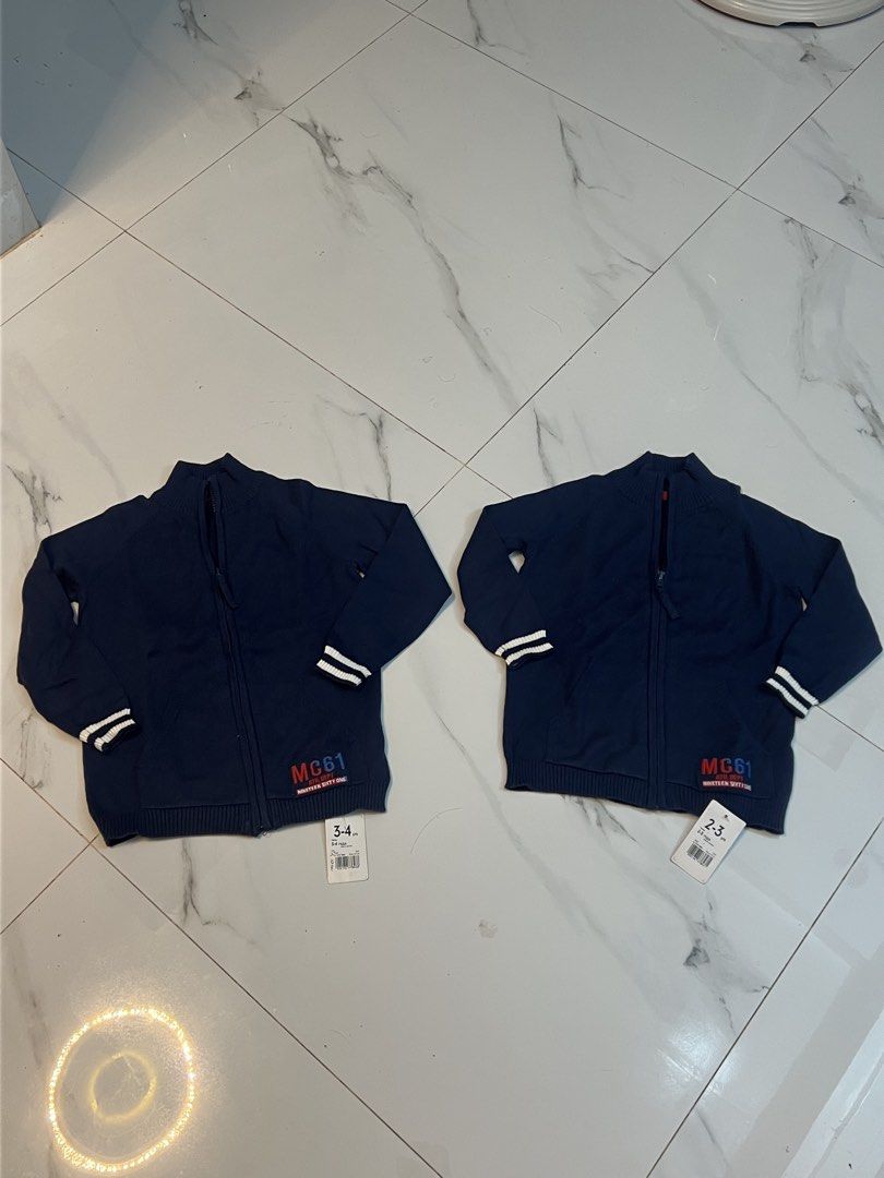 Boys Navy Blue Knit Zip-Up Jacket MC61 (Category: Babies & Kids Fashion) located in Gapan. Submitted by arieltinio (Listing ID 1464936852, Image 3). Description: - Brand: New with tags (BNWT) - Color: Navy blue with white & navy sleeve stripes - Style: Mock neck zip-up knit jacket with front kangaroo pocket - Details: Ribbed cuffs/hem, embroidered 'MC61 Ath. Dept.' patch - Condition: Brand new, never worn - Perfect for: Casual everyday wear or co