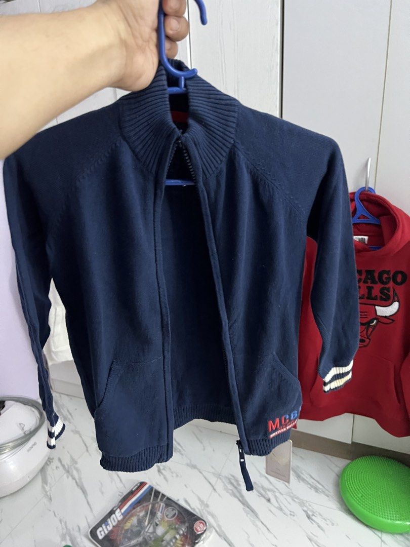 Boys Navy Blue Knit Zip-Up Jacket MC61 (Category: Babies & Kids Fashion) located in Gapan. Submitted by arieltinio (Listing ID 1464936852, Image 1). Description: - Brand: New with tags (BNWT) - Color: Navy blue with white & navy sleeve stripes - Style: Mock neck zip-up knit jacket with front kangaroo pocket - Details: Ribbed cuffs/hem, embroidered 'MC61 Ath. Dept.' patch - Condition: Brand new, never worn - Perfect for: Casual everyday wear or co