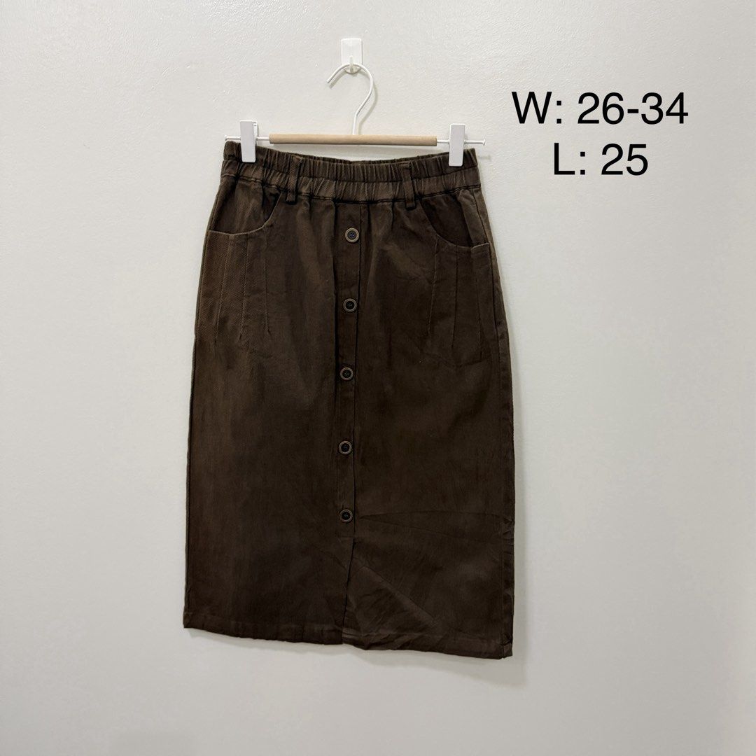 Brown button-down midi skirt with elastic waist (Category: Skirts) located in Rodriguez. Submitted by jrms23 (Listing ID 1464962122, Image 1). Description: - Color/Fabric: Rich brown corduroy-like textured fabric - Closure & Details: Front button placket with deep front pockets on both sides - Waistband: Comfortable elastic stretch, fits 26 to 34 inches - Length: Midi length, measures 25 inches total - Styling: Easy to pair with casual tees or co