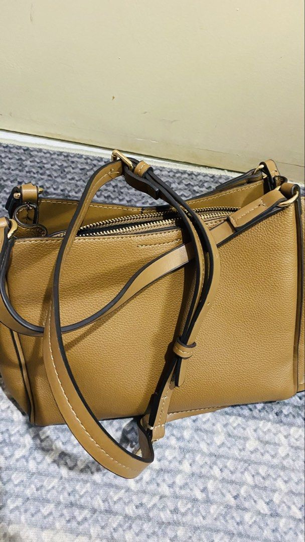 Brown Faux Leather Shoulder Bag with Adjustable Strap (Category: Cross-body Bags) located in Santiago. Submitted by kjuvieann39 (Listing ID 1464803952, Image 2). Description: - Color/Material: Brown pebbled faux leather - Hardware: Gold-tone throughout - Compartments: Center zippered divider with two open sections - Interior: Black fabric lining with an inner zip pocket and branded leather patch - Strap: Includes matching adjustable and detachabl