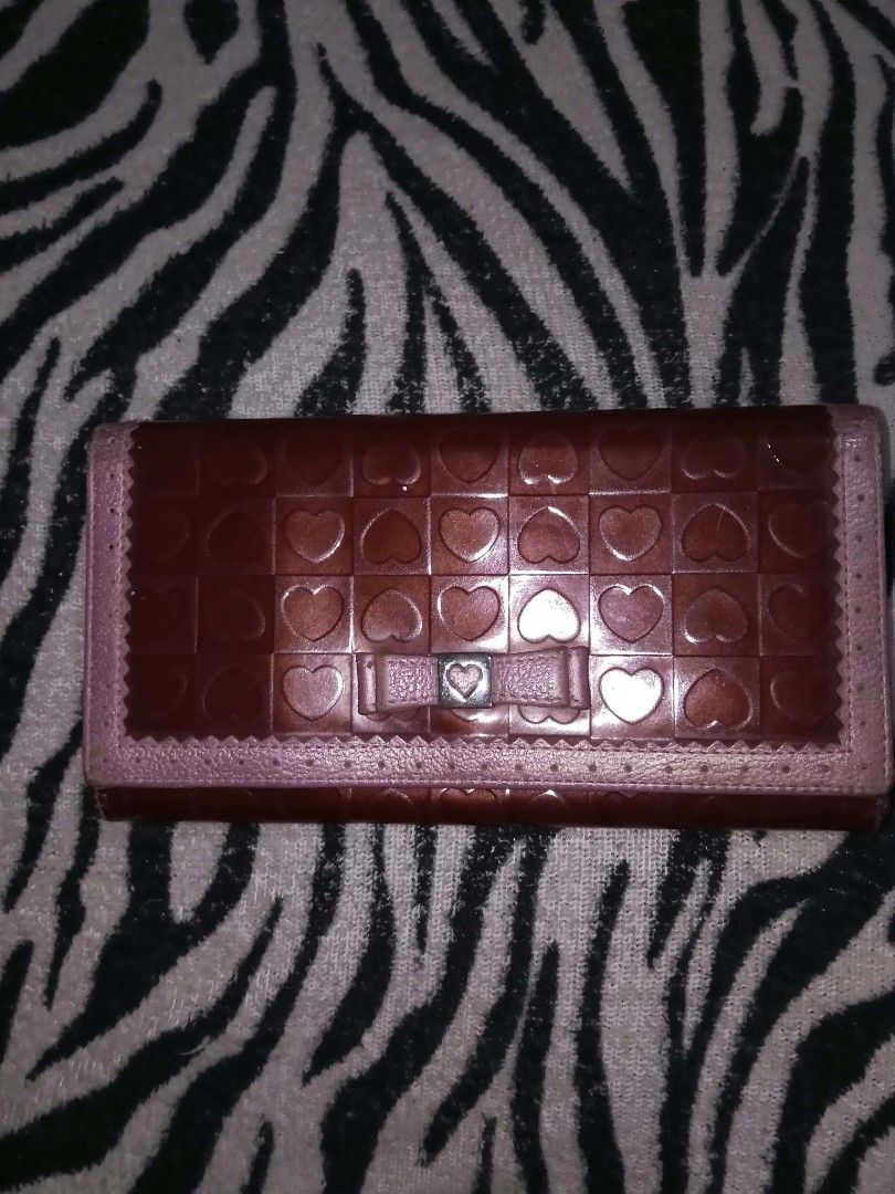 Brown Long Wallet with Heart Pattern and Bow Detail (Category: Wallets & Card holders) located in Valenzuela. Submitted by rowenasalvador777 (Listing ID 1464968521, Image 1). Description: - Color: Brown faux leather - Design: Glossy checkerboard texture with all-over stamped hearts, matching center bow, and tiny metal heart accent - Trim: Scalloped edges along the front flap - Closure: Simple snap closure - Capacity: Spacious long rectangular sha