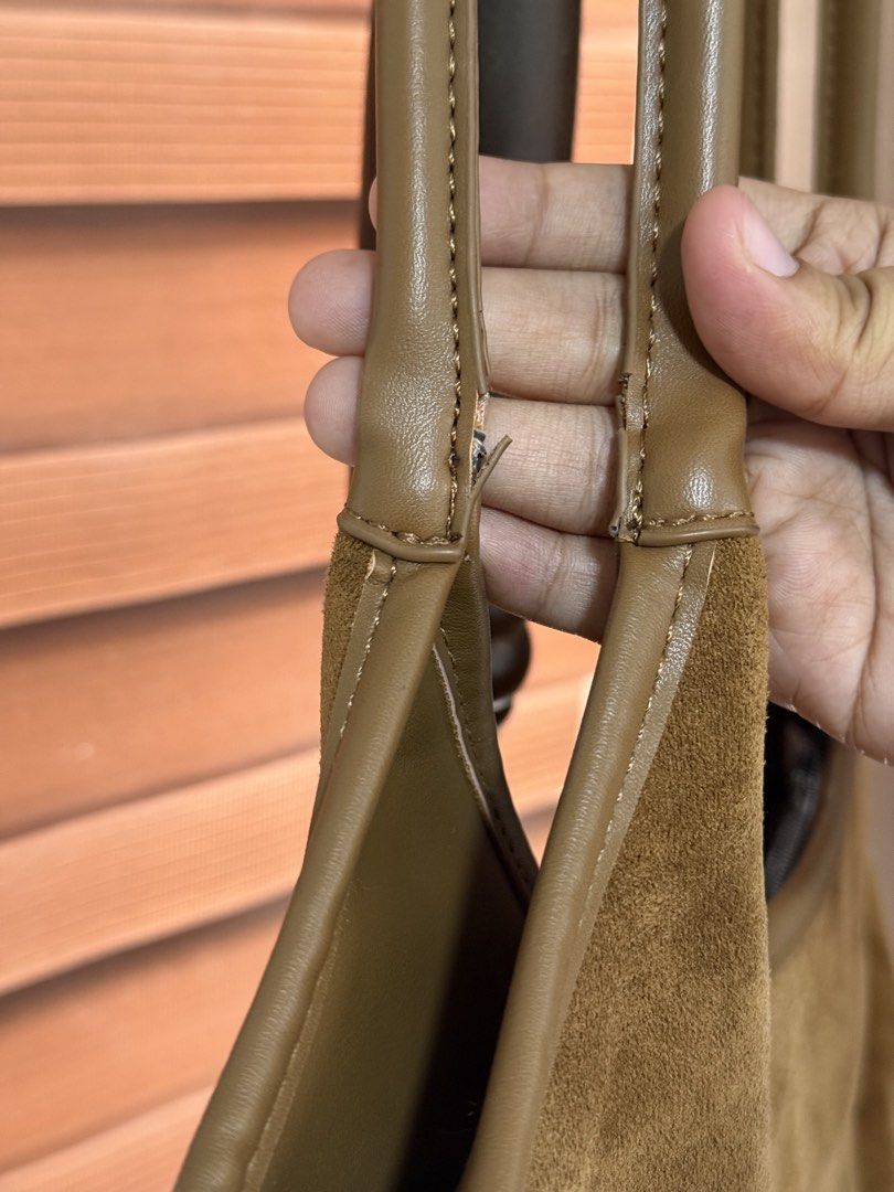 Brown suede shoulder bag with leather straps (Category: Shoulder Bags) located in Imus. Submitted by neirasalonga_ (Listing ID 1464790721, Image 2). Description: - Stylish brown suede shoulder bag, perfect for everyday wear - Features faux leather handles, top trim, and stitched strap details - Spacious main compartment to fit all your daily essentials - Flaw/Condition note: Some wear and splitting on the handle stitching near the base (please ch