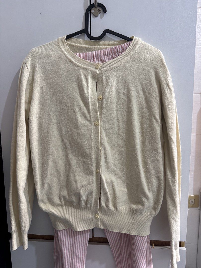 Butter Yellow Knit Button-Up Cardigan (Category: Coats, Jackets and Outerwear) located in Manila. Submitted by d.clutterrr (Listing ID 1464783424, Image 1). Description: - Color: Cream with subtle pink and white striped neckline lining - Material: Soft textured knit, warm and comfortable - Design: Long sleeves, front button closure, ribbed cuffs and hem - Fit: Standard fit, versatile basic piece for everyday layering - Condition: 7/10 .