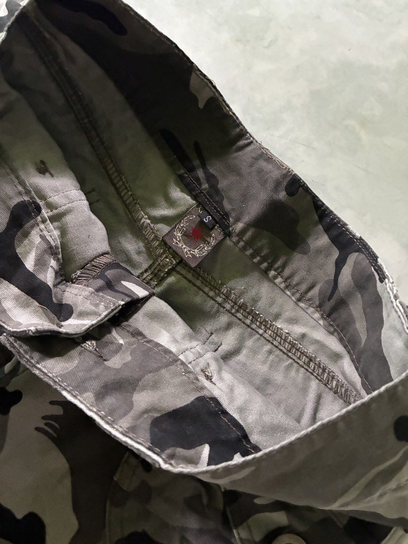 Camou Shorts (Category: Shorts) located in Batangas. Submitted by jinventoryarchive (Listing ID 1464871001, Image 3). Description: Waist: 28 Length: 10.5 Leg Op: 9.8 - Size: S - Color: Green camo print - Style: Cargo shorts with roll-up cuffs - Pockets: Multiple utility pockets and button-flap back pockets - Details: Waistband with belt loops and secure button closure.