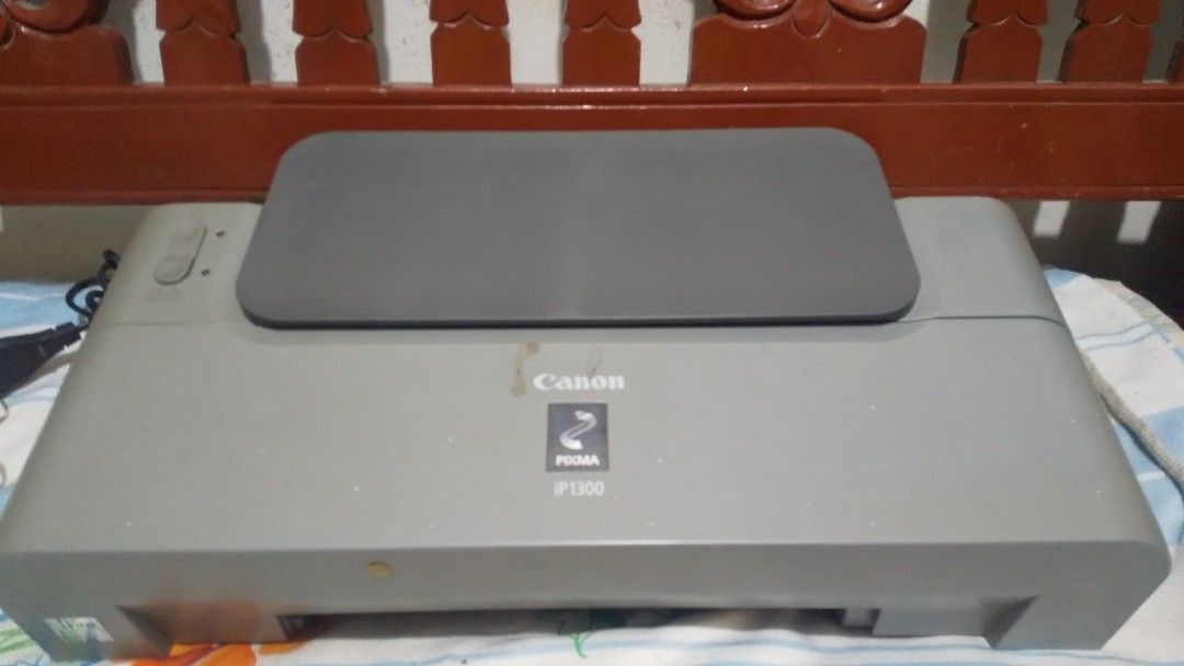 Canon PIXMA iP1300 Inkjet Printer (Category: Printers, Scanners & Copiers) located in Binan City. Submitted by rpute (Listing ID 1464879871, Image 2). Description: - Model: Canon PIXMA iP1300 Printer - Color: Grey - Condition: Normal exterior wear, powers on and fully functional - Features: Top paper feeder, ready for basic document and photo printing - Inclusions: Power cable included.