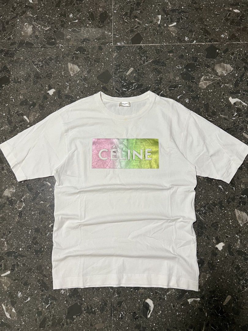 Celine Paris Gradient Logo White T-Shirt Size M (Category: Shirts) located in San Fernando. Submitted by justin_sy (Listing ID 1464887735, Image 1). Description: - Brand: Celine Paris - Color: Crisp white with metallic pink-to-green gradient graphic - Size: M (verified via inner tags) - Material: Premium cotton with a clean finish - Design: Short sleeves, classic crew neck, and raised white Celine lettering - Condition: Excellent, clean fabric.