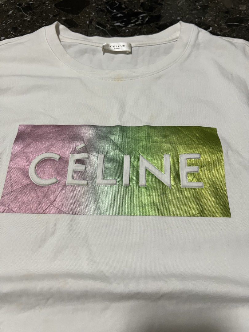 Celine Paris Gradient Logo White T-Shirt Size M (Category: Shirts) located in San Fernando. Submitted by justin_sy (Listing ID 1464887735, Image 2). Description: - Brand: Celine Paris - Color: Crisp white with metallic pink-to-green gradient graphic - Size: M (verified via inner tags) - Material: Premium cotton with a clean finish - Design: Short sleeves, classic crew neck, and raised white Celine lettering - Condition: Excellent, clean fabric.