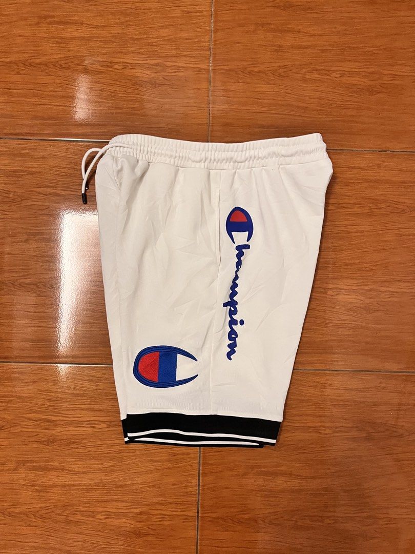 Champion White Athletic Shorts XXL (Category: Shorts) located in Calasiao. Submitted by cristinabarongan5 (Listing ID 1464835945, Image 2). Description: - Brand: Champion - Color: White with black & white striped cuffs - Size: XXL - Material: 100% nylon body, 100% cotton lining - Features: Elastic waistband, adjustable drawstring, dual side logos, and vertical script logo - Origin: Made in Vietnam - Condition: Clean and ready to wear - Size 32-38